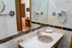 a bathroom with a sink and a mirror at Hotel Malena in Caravaca de la Cruz