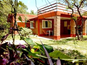 una casa naranja con una mesa delante en Dorado del Sol en Merlo