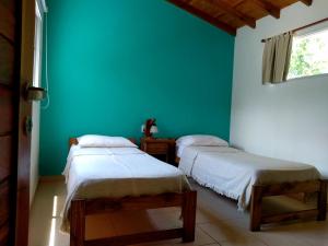 two beds in a room with a blue wall at Dorado del Sol in Merlo