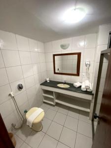 uma casa de banho com um lavatório, um WC e um espelho. em JL Temporadas - Quarto Portobello Park Hotel em Porto Seguro