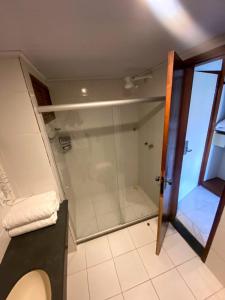 uma casa de banho com uma cabina de duche em vidro e um WC. em JL Temporadas - Quarto Portobello Park Hotel em Porto Seguro