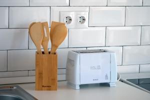 a kitchen counter with two wooden spoons and a microwave at LOFT CANET DE MAR CERCA de BARCELONA in Canet de Mar +11 photos