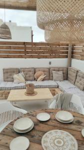 een houten tafel met witte platen erop bij NOMAD SURF HOUSE in Corralejo