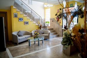 un vestíbulo con sofás, una mesa y escaleras en Hotel Malena, en Caravaca de la Cruz