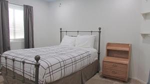 a bedroom with a bed and a wooden night stand at Cozy home near freeways w pool BBQ in Peoria