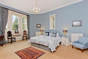 1 dormitorio azul con 1 cama y 1 silla en Dalnaglar Castle, en Blairgowrie