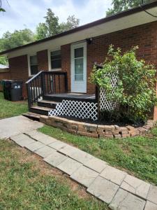 une maison en briques avec une terrasse couverte et un escalier dans l'établissement 2BR 1BA Duplex House King Beds Great for Small Groups Close to All Uptown Charlotte attractions, à Charlotte