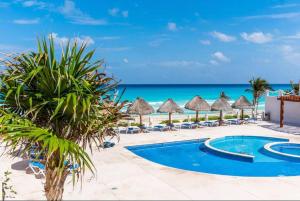 un complejo con piscina y playa en Villas Marlin by Andiani Travel, en Cancún