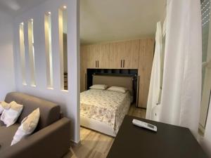 uma sala de estar com uma cama e um sofá em La maison du mar em Bari