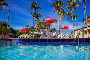 a pool at a resort with chairs and umbrellas at Caldas Park & Hotel XPTO Turismo in Caldas Novas