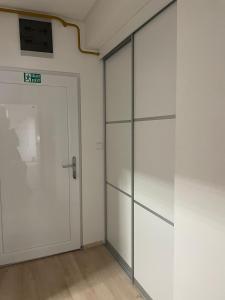 una puerta de cristal en una habitación con una pared blanca en Apartman Botivo en Ludbreg