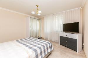 a bedroom with a bed and a flat screen tv at Прекрасная 2 комнатная квартира в центре Кишинева in Chişinău