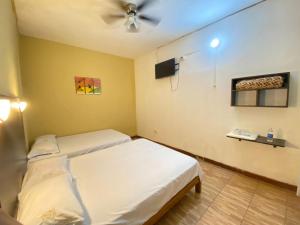 a room with two beds and a ceiling fan at Pirhua Hotel Boutique in Piura