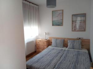 1 dormitorio con 2 camas con sábanas a rayas y vestidor en Ocean View Malpica VUT en Malpica
