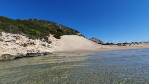 Villa Dunes 350m from the sandy beach في كالوغريا: شاطئ فيه الكثبان الرملية بجانب الماء