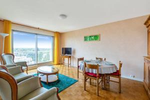 uma sala de estar com uma mesa e cadeiras e uma grande janela em Nice 2 stars apartment with balcony - Vincennes - Welkeys em Vincennes