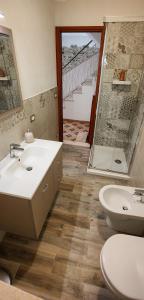 La salle de bains est pourvue d'un lavabo, de toilettes et d'une douche. dans l'établissement SweetHome in Erice Vetta, à Erice