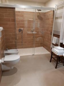 uma casa de banho com um WC e uma cabina de duche em vidro. em La Locanda del Collaccio em Preci