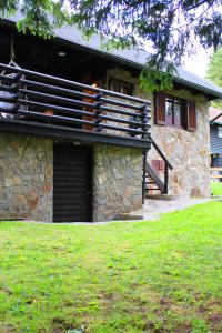 a stone house with a garage and a porch at Apartment Bajta - Rogla in Zreče