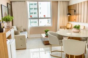 mały salon ze stołem i krzesłami w obiekcie Ramada Hotel & Suites Campos Pelinca w mieście Campos dos Goytacazes