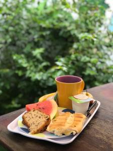a plate of food with bread and a cup of coffee at La Casa Hostel in Arraial do Cabo