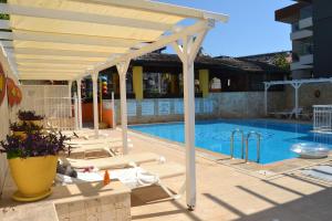 a white pergola over a swimming pool at Safari Suit Hotel , Side in Side