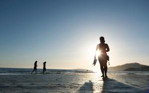 two people walking on the beach at sunset at Hotel Miramar Playa America Nigran in Nigrán