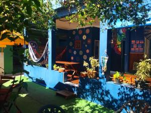 a house with blue walls and potted plants at La Casa Hostel in Arraial do Cabo