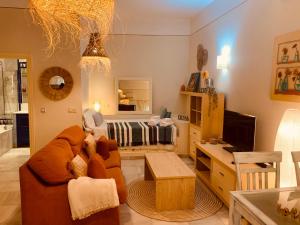 a living room with a couch and a bed at Lovely studio in Marbella close to Puente Romano in Marbella