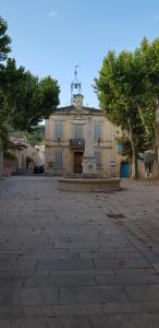 un bâtiment avec une statue au milieu d'une cour dans l'établissement Jolie maison de ville La Petite Magnanerie, à La Roque-dʼAnthéron