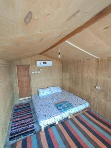 a large bed in a room with a wooden ceiling at Sinai Life Beach Camp in Nuweiba