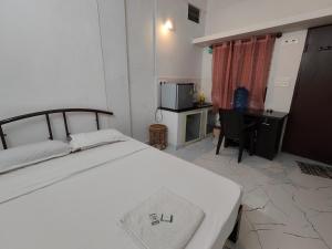 1 dormitorio con 1 cama y escritorio con ordenador en Yoga House, en Vānivilāsa Puram