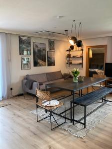 a living room with a table and a couch at DAS ERWIN Design-Bungalow (Nähe Velden/Wörthersee) in Sankt Jakob im Rosental