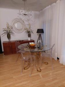 uma sala de jantar com uma mesa de vidro e cadeiras em Apartamento Orquídea em Ponta Delgada