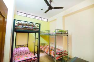 two bunk beds in a room with a ceiling fan at Pink City Hostel in Jaipur