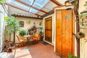a conservatory with a wooden door and a table and chairs at Maggiore 145 apartment with private garden - Rione Monti in Rome