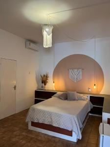 Un dormitorio con una cama grande y una lámpara de araña. en Barra lounge, en Maragogi