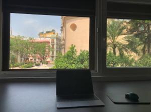 a laptop sitting on a desk in front of a window at Valencia Old Town EL CARMEN. in Valencia