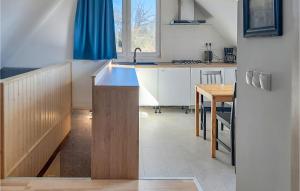 uma cozinha com um lavatório e uma mesa com uma cortina azul em Gorgeous Apartment In Wolin With Wifi em Wolin