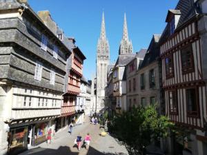 a group of people walking down a street with buildings at Sweet home en plein coeur de Quimper in Quimper