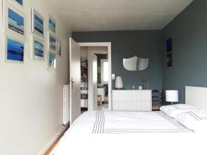 sypialnia z białym łóżkiem i szarą ścianą w obiekcie Sweet home en plein coeur de Quimper w mieście Quimper