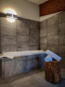 łazienka z wanną i drewnianym kijem w obiekcie Chalet Lago w mieście Taverna