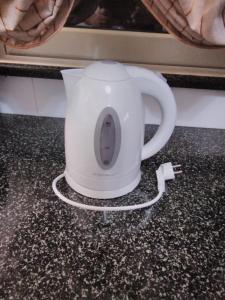 a white tea kettle sitting on a counter at Case vacanze Vito e Alessia 96-01 Capaci PA in Capaci