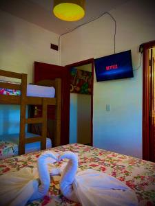 a bedroom with a bed with two swans on it at Residencial Bem-te-vi in Jericoacoara