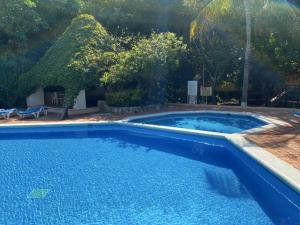 a large blue swimming pool in a yard at Perla y Tropical By Andiani in Cancún