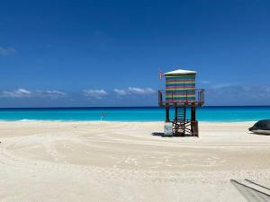 a colorful chair sitting on a sandy beach at Perla y Tropical By Andiani in Cancún