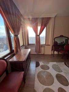 a living room with large windows and a table at Dalv Residence - SPA Fairy Tale in old Sofia in Sofia
