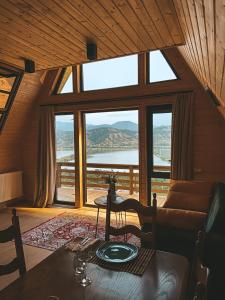 ein Wohnzimmer mit einem Tisch und einem großen Fenster in der Unterkunft La Baita - ლა ბაიტა 2 in Tbilisi City