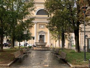 Casa dai Toni Cortesi 2 في بيرغامو: مجموعة من المقاعد أمام مبنى به نافورة