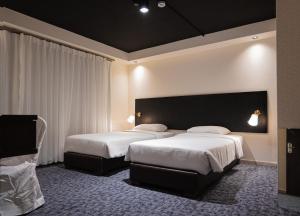 une chambre d'hôtel avec deux lits et une grande tête de lit dans l'établissement Diamond Hotel, à Amman